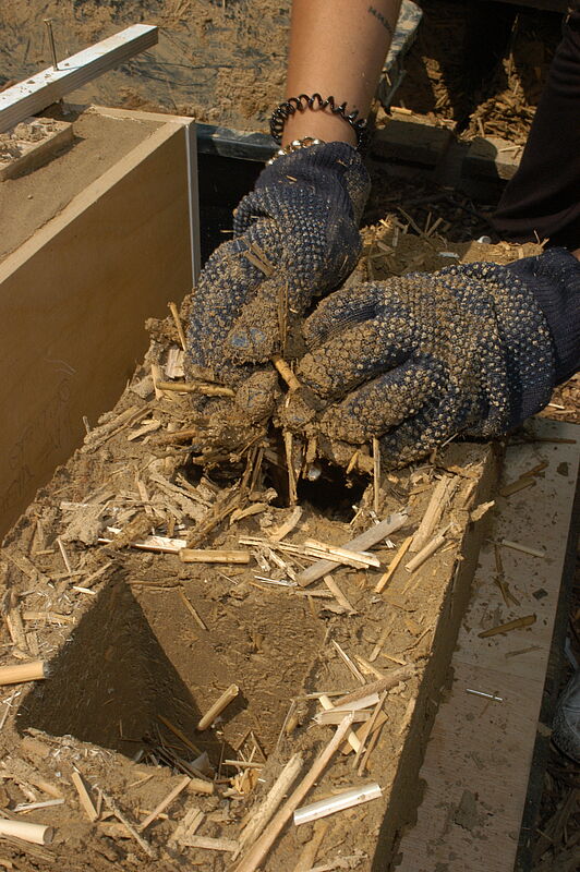 Als Formen für die Leichtlehmziegel lassen sich Reste von mitteldichten Faserplatten verschrauben, in die von oben die Mischung aus Lehm und Reet-Hackschnitzeln gefüllt wird.